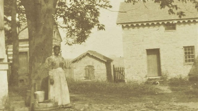 c. 1897 image of a tenant farmer woman outside the Enslavement Quarters. NPS