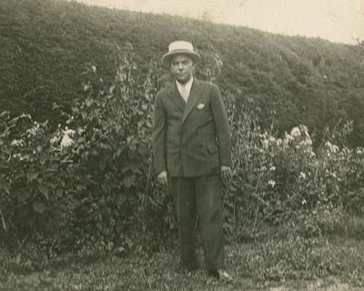 Irvin McDuffie in suit and tie standing in a garden.