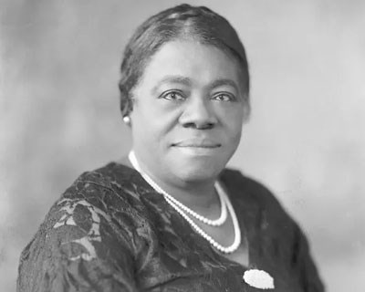 Portrait of Mary McLeod Bethune wearing a dark dress and double strand of pearls