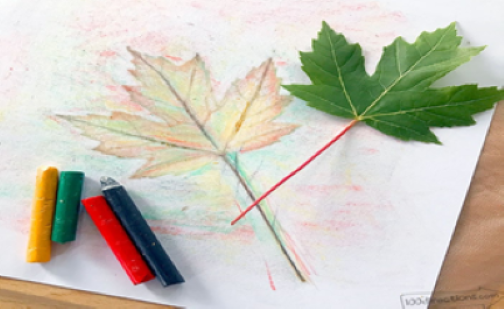 a piece of paper with crayons, a leaf, and a leaf print
