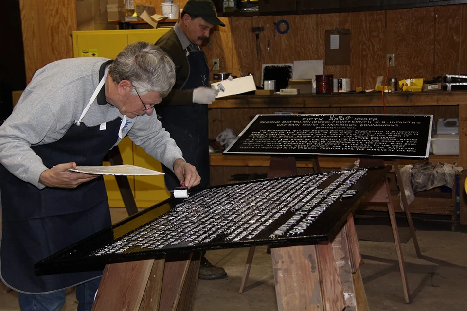 Iron Brigade Volunteer at Work Volunteer paints one of the War Department tablets.