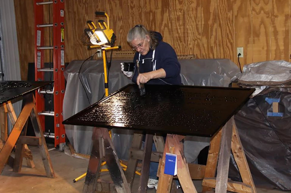 Volunteer Working on War Department Tablets Volunteer paints the black background of one of the War Department tablets.