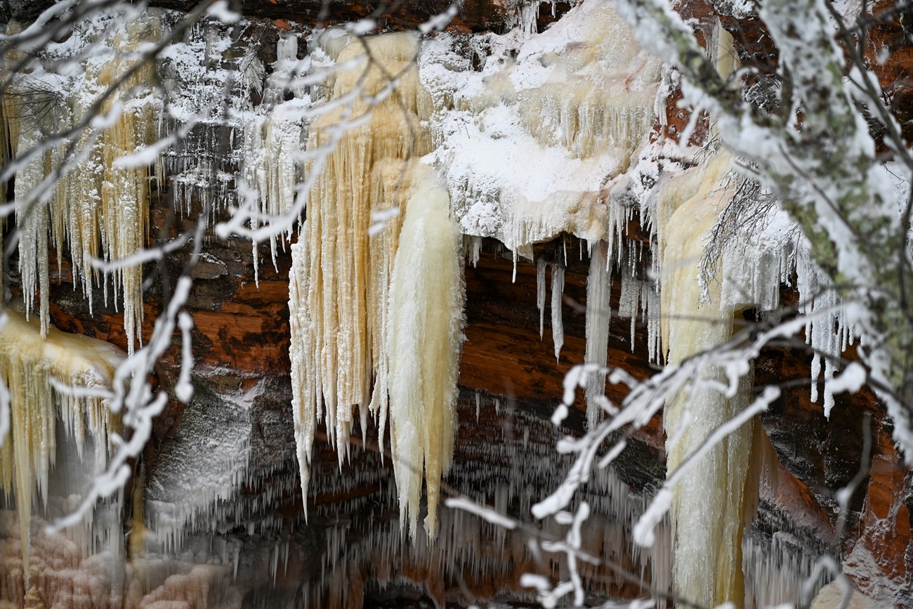 Mainland Sea Caves Ice Formations Red sandstone cliffs draped in icicles and ice columns of various sizes.