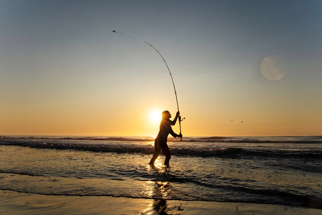 An angler casting out at sunset