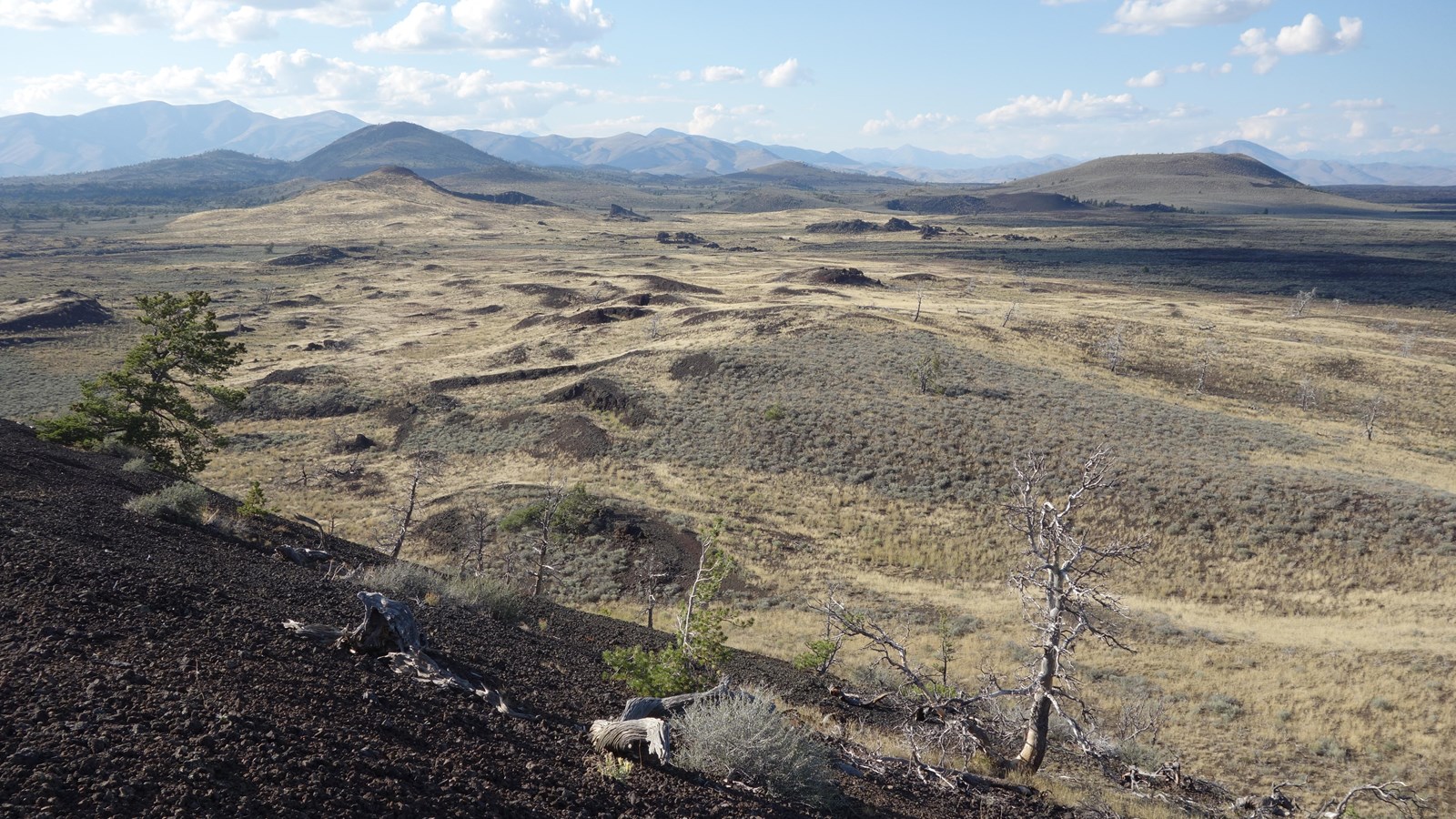several cinder cones rising from a wide open sagebrush-covered landscape