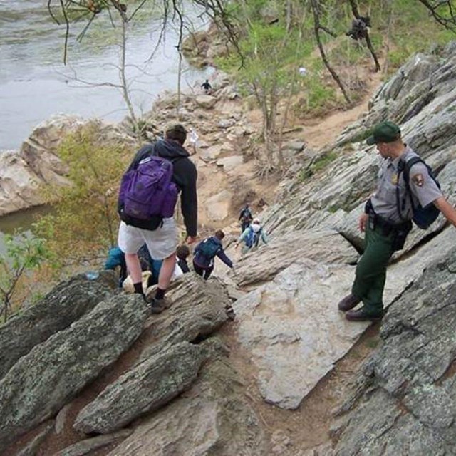 Visitors climb down a rockface