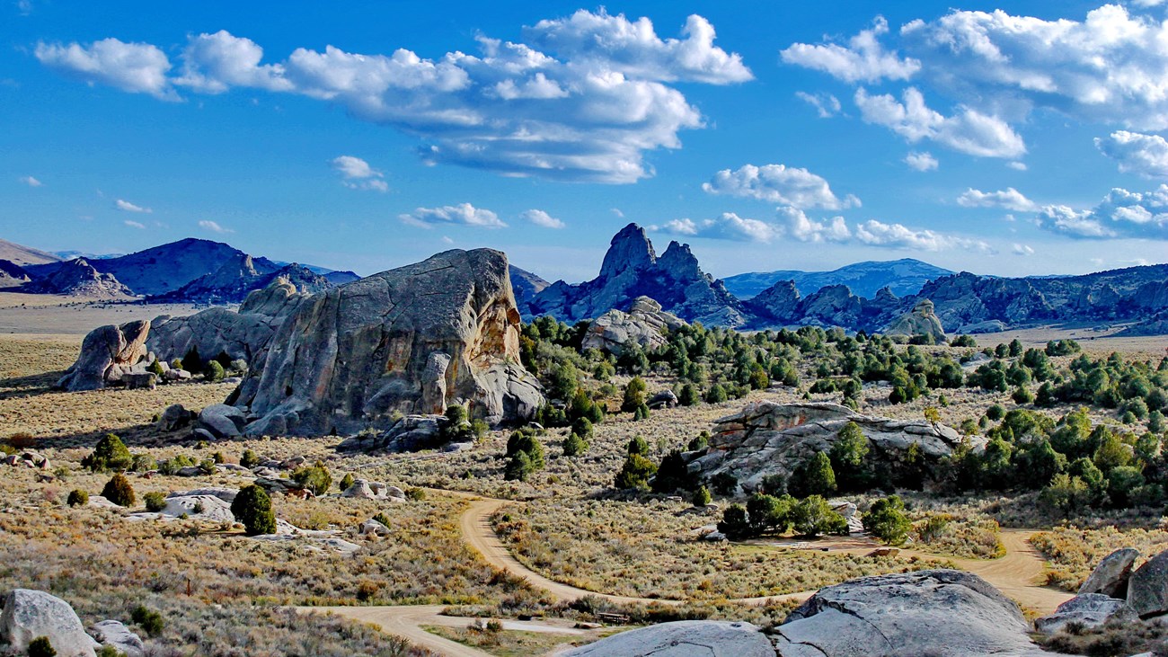 A scenic vista of rocks formations and trails. A cloudy sky is seen.