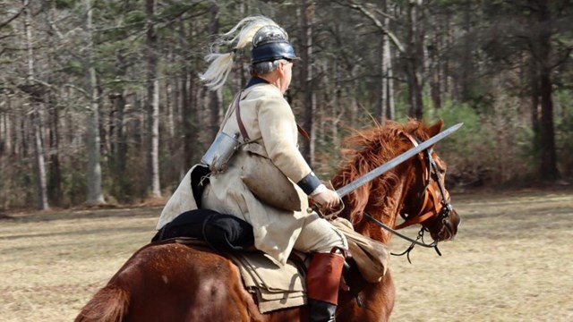 Reenactors in hunting frock walks through woods