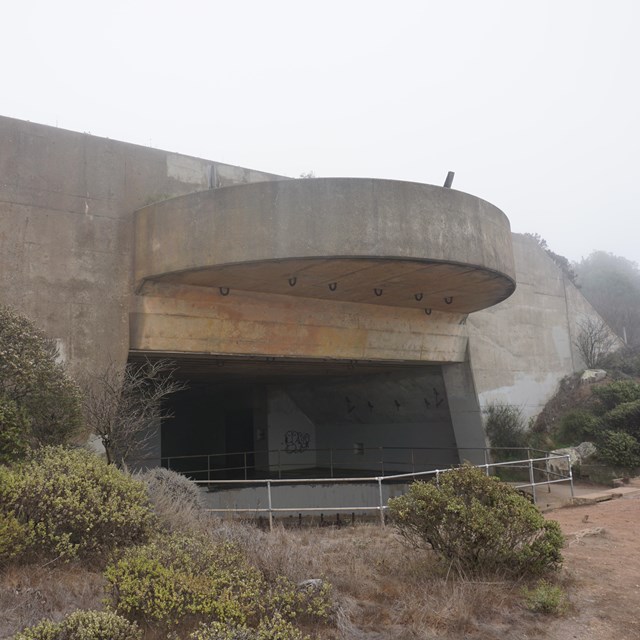 What would have been the gun casemate, a large concrete semi-cricle protruding from a tunnel.