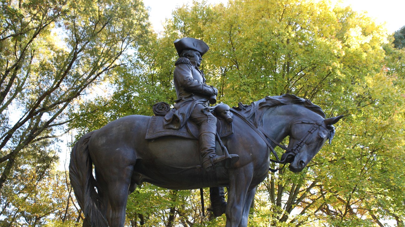 A side view of the Greene monument. General Greene's statue is posed atop a horse.