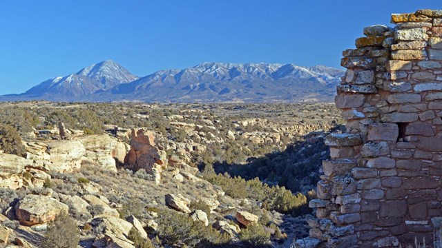 stone structure with canyon and Sleeping Ute Mountain in background
