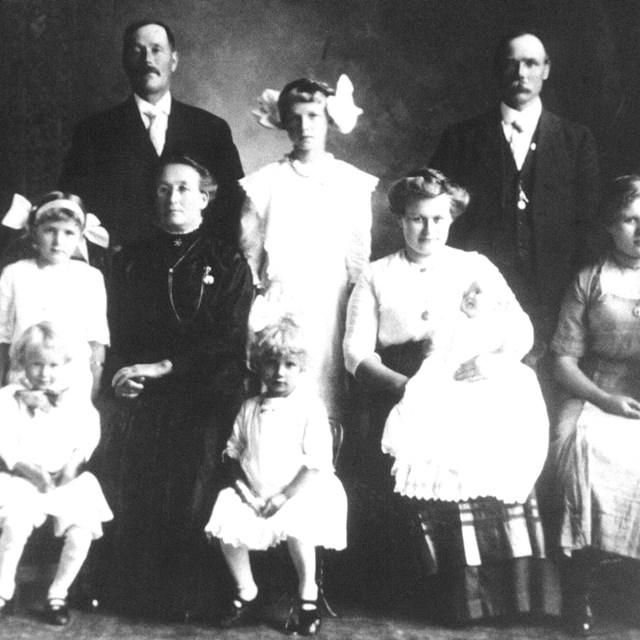 A group of people standing and sitting who are posing for a photograph.