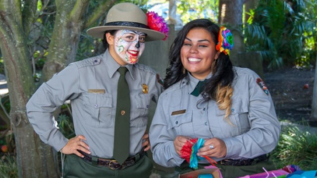 Two park rangers with celebratory attire for Dia De Los Muertos