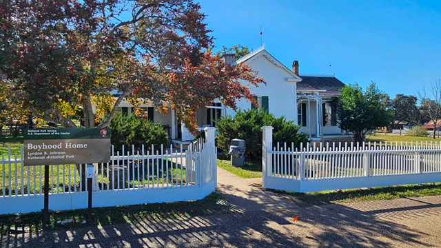 Small, white house with white picket fence