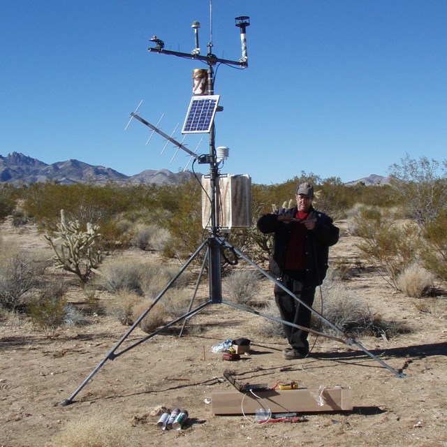A scientist installs a weather station in Mojave Preserve.