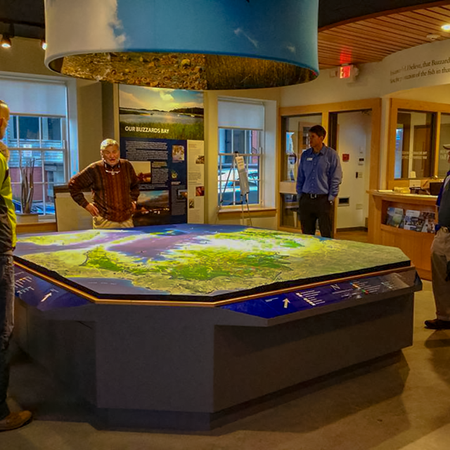 Interior of Buzzards Bay Center with a group gathered around a map.