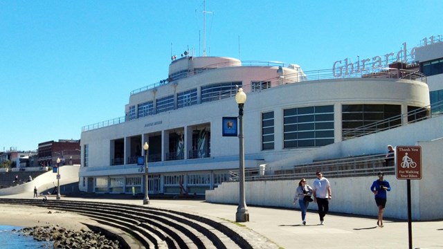 a white building designed to look like an ocean liner ship near a rocky shoreline