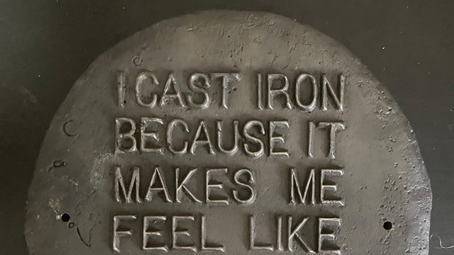 Circular cast iron plaque with the words "I cast iron because it makes me feel like part of a whole"