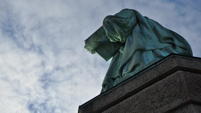 A photo of the Statue of Liberty from the top of the pedestal looking up at the statue.