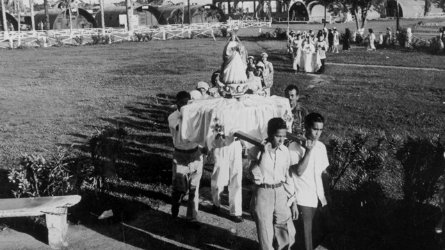 A group of men carry a platform in a funeral procession