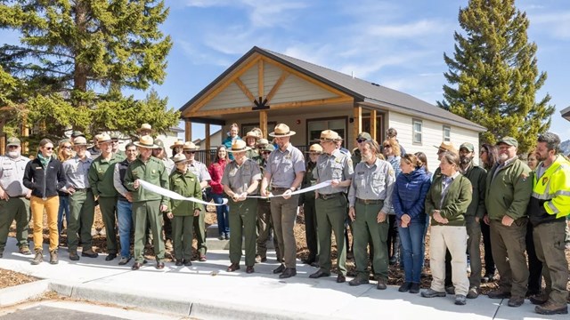 a group of National Park Service employees in front of brand-new housing
