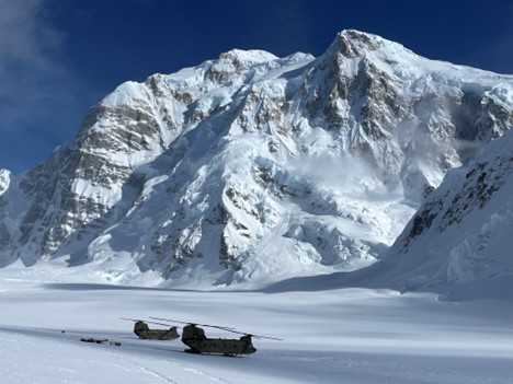 A Chinook has significantly more cargo space than our high-altitude helicopter Two large helicopters at the base of a snow mountain