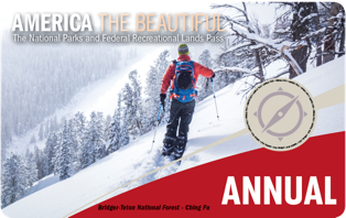 America The Beautiful Annual Pass; a man in a red jacket, skiing on a snowy mountainside