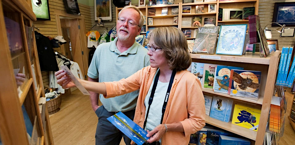 Alaska Geographic bookstore at Denali National Park Man and woman browsing postcards in a bookstore
