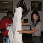 Hampton NHS staff unwraps a harp to reinstall it in the mansion