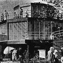 old photo of a round house with large windows, three stories tall with each level being smaller than the one below