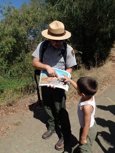 Park Ranger shows a young boy a photo book during a presentation. Park Ranger shows a young boy a photo book during a presentation.