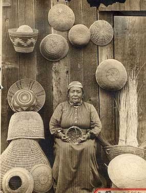 Historic photo of a woman surrounded by many woven baskets