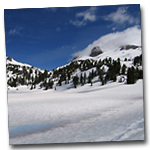 lake helen is seen thawing out with lassen peak in the background.