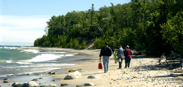 Visitors to Pictured Rocks National Lakeshore enjoy the beautiful beaches of Lake Superior as the waves roll gently in.