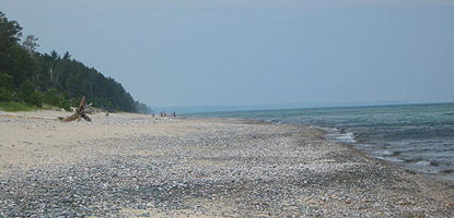 Waves roll gently in on a hazy day at the Twelvemile Beach along Lake Superior.