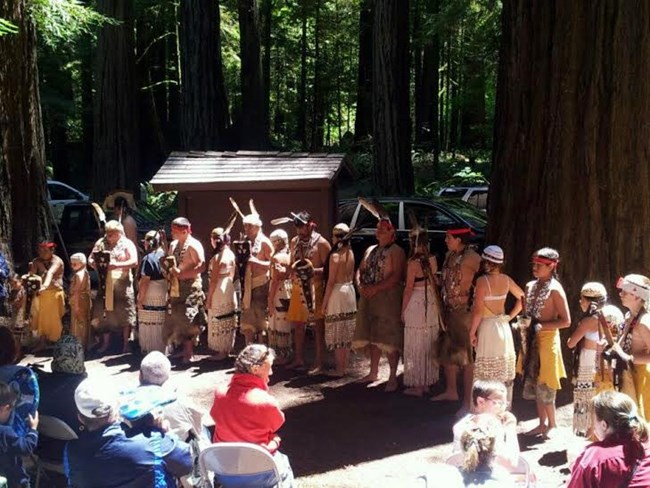 Tolowa dancers line up in front of a crowd.