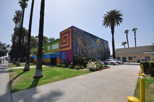 driveway next to a large building with a mural showing