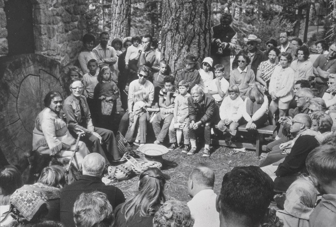 historic photo of a group of visitors listening to a ranger program