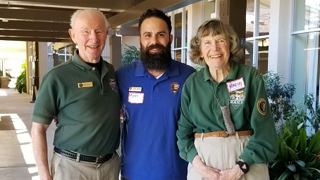 Trails & Rails Docents Park Ranger and two Trails and Rails volunteers standing together and smiling outside of a classroom for their photo to be taken.