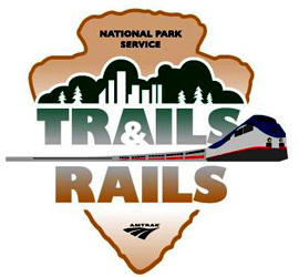 trailsrailslogo Trails & Rails logo with a National Park Service Arrowhead with an Amtrak train through the middle.