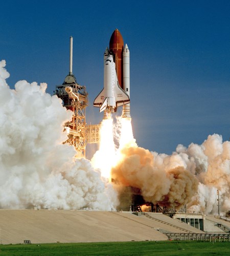 Space Shuttle Launch Two large white rockets and a large red tank attached to a space plane blasting off