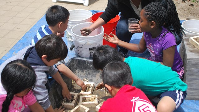 Kids making adobe bricks