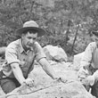 Cutting Tuff Boulder in Half with Handsaw - Rock Being Cut for Museum in Background