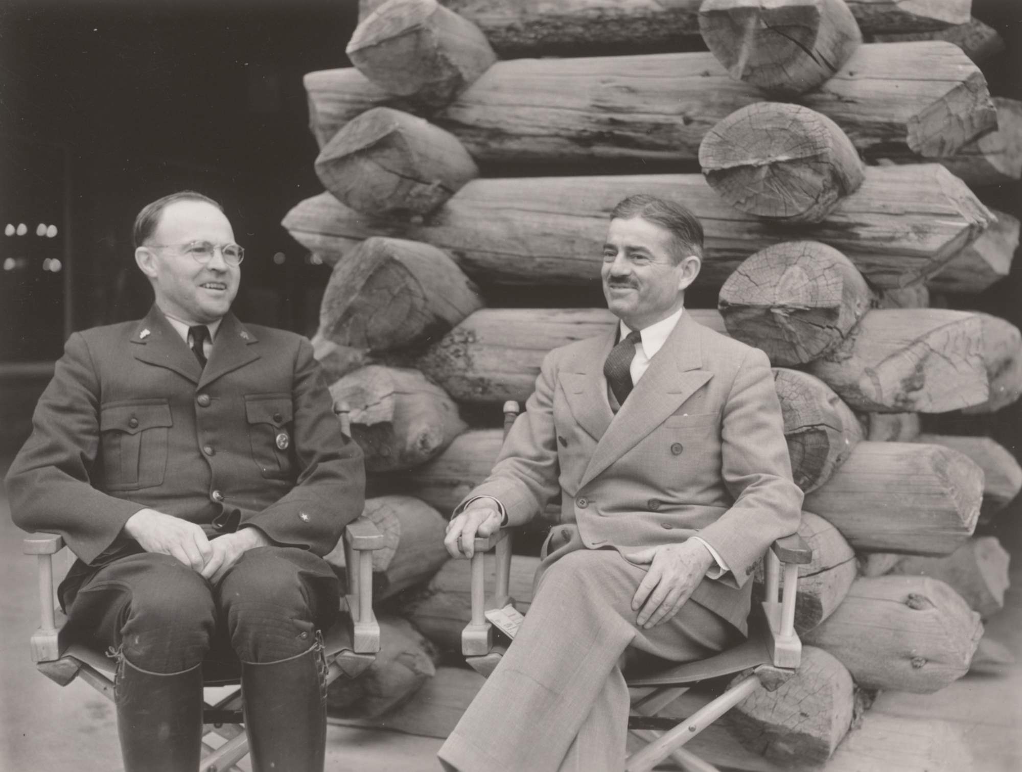 Six men stand in NPS uniforms with broad brim hats. Frank Pinkley wears a round superintendents badge and another ranger wears a shield-shaped badge.