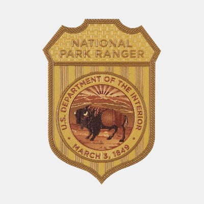 Metal Badge A yellow badge with the US Department of the Interior seal and the words National Park Ranger