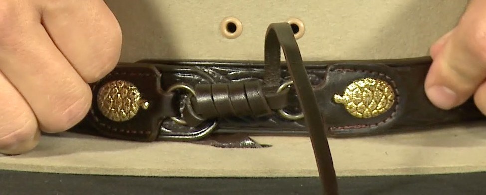 Tying the Hatband Step 5 A close-up of a cord looped around itself several times on the hatband of a ranger hat