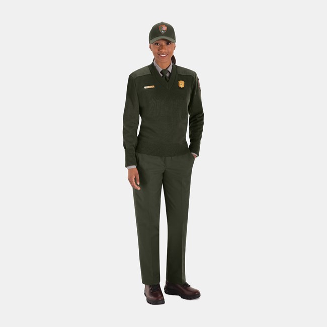 Winter Field Uniform An NPS employee wearing a green ball cap, tie, sweater, and pants, and brown shoes