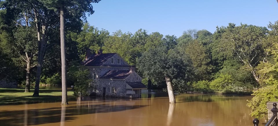 Washington's HQ at Valley Forge flooded by the remnants of Hurricane Ida murky brown floodwaters cover the base of a historic two story stone and its nearby trees