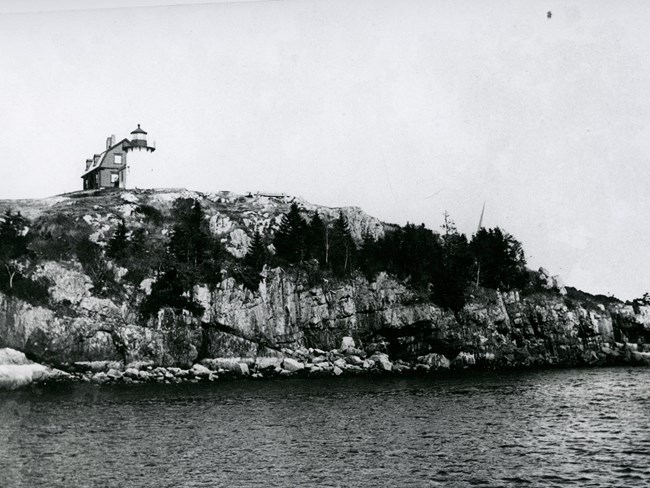 Historic photograph of a light station on a rocky island