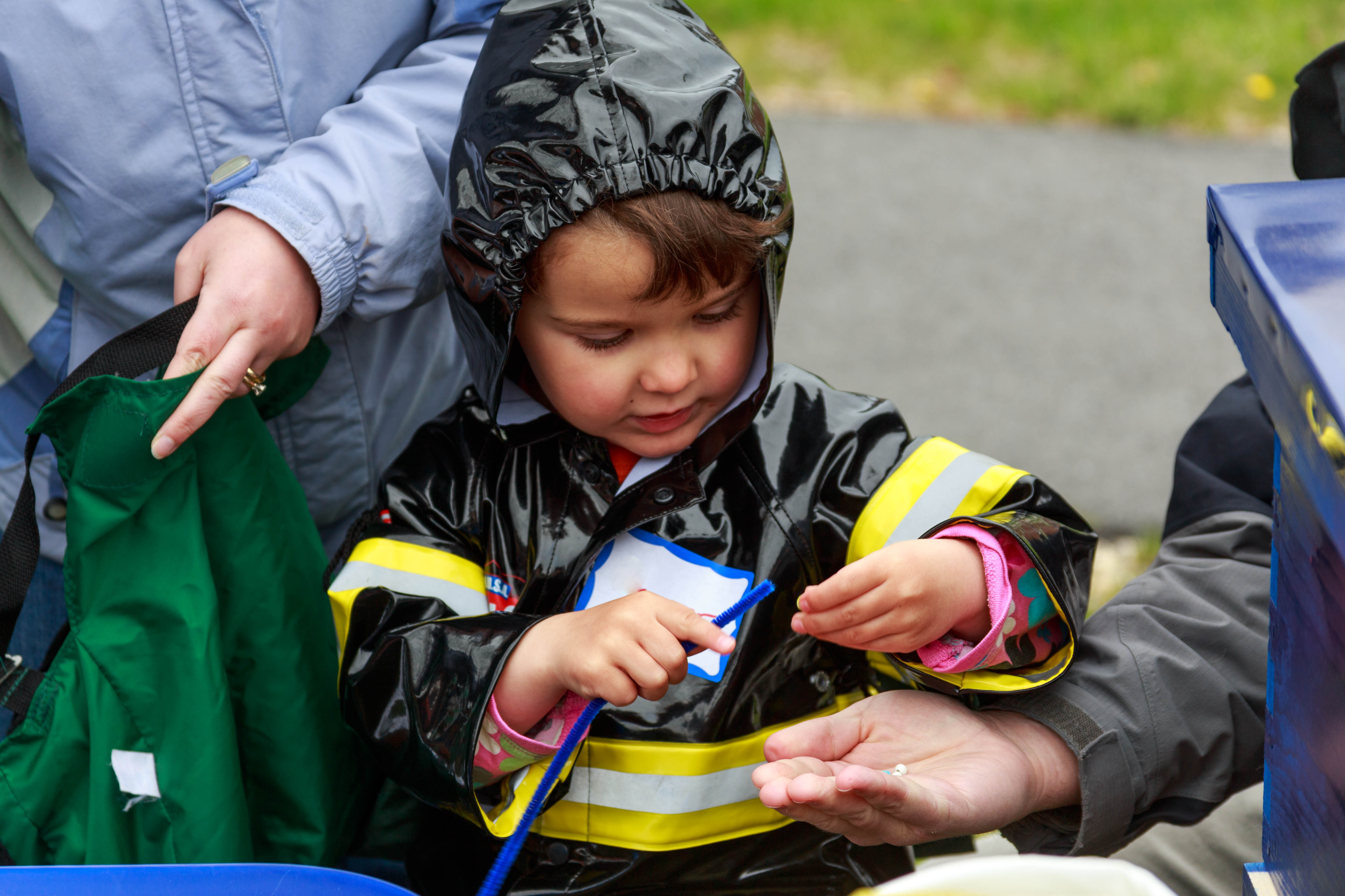 Junior Ranger playing a pollen game in a black rain slicker.